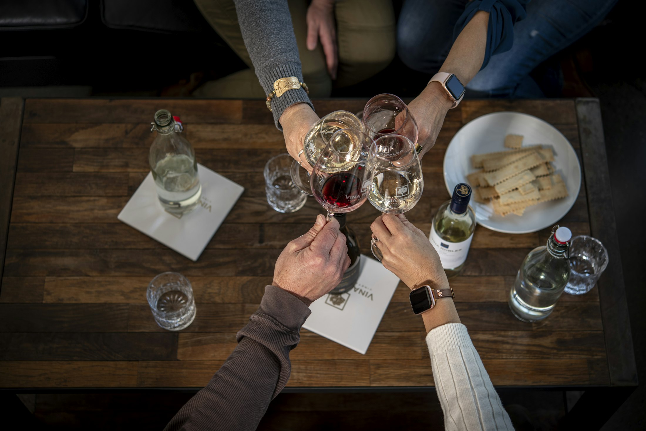 People gathered around a table to cheers with wine