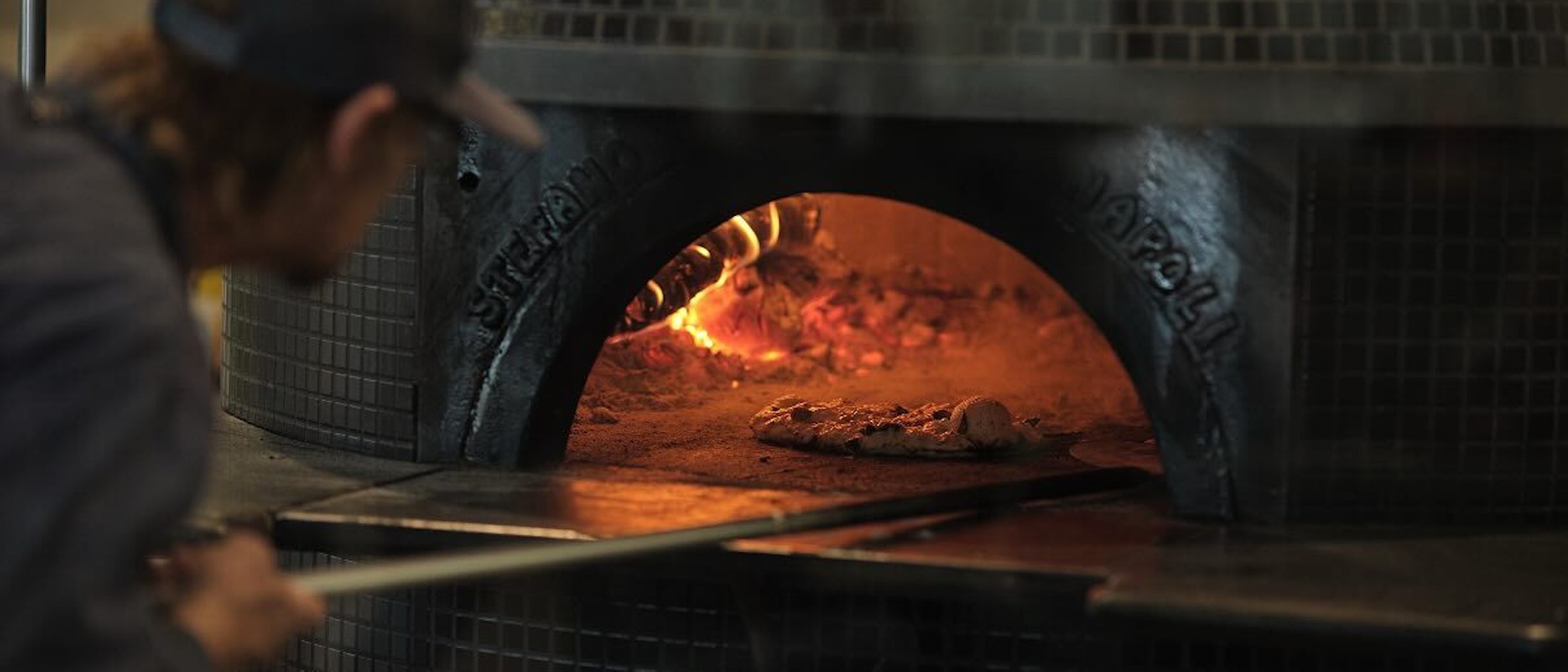 Turning pizza in wood fired oven